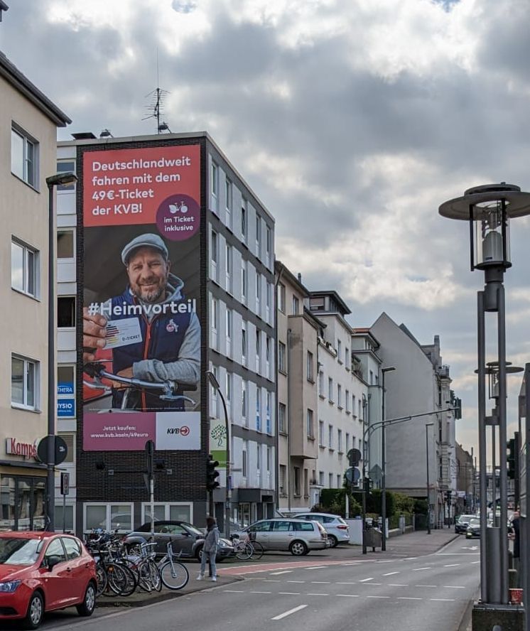 Werbung für das 49€-Ticket an einer Hausfassade in Köln.