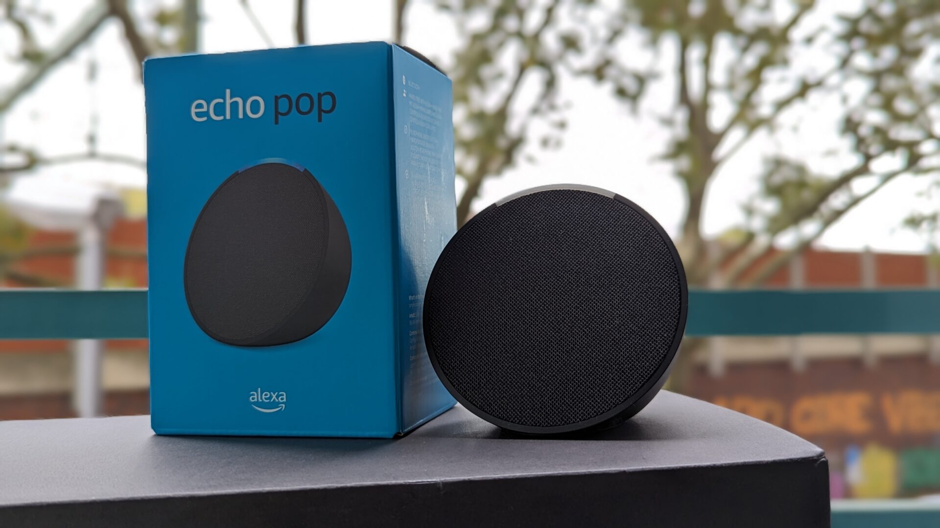 Ein Amazon Alexa Echo Pop als Gerät und Verpackung.